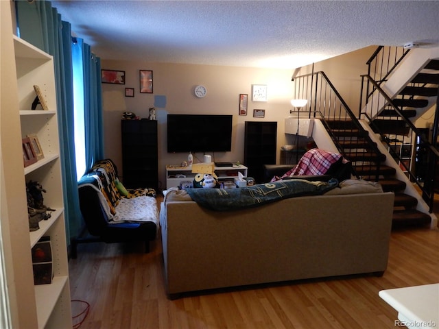 living room featuring wood-type flooring and a textured ceiling