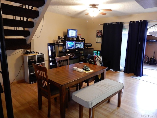 dining space featuring ceiling fan, light hardwood / wood-style floors, and a textured ceiling