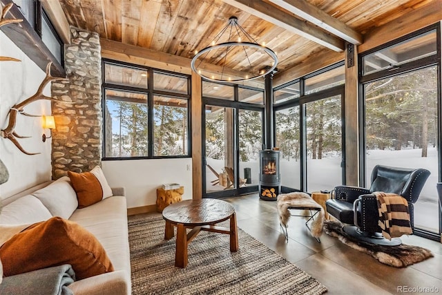 sunroom featuring a wood stove, wooden ceiling, and beamed ceiling