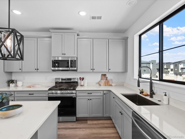 kitchen featuring visible vents, light wood finished floors, recessed lighting, a sink, and appliances with stainless steel finishes