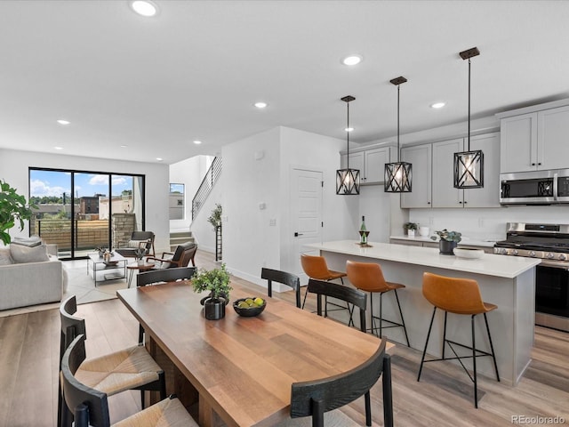 dining space with recessed lighting, light wood-type flooring, stairs, and baseboards