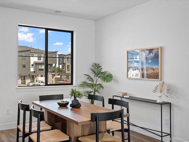 dining area with baseboards and wood finished floors