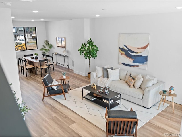 living area with recessed lighting, baseboards, and wood finished floors