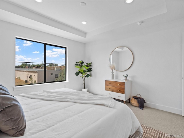 bedroom with a raised ceiling, recessed lighting, carpet, and baseboards