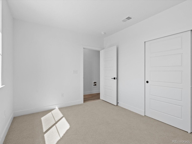 unfurnished bedroom with visible vents, baseboards, a closet, and carpet flooring