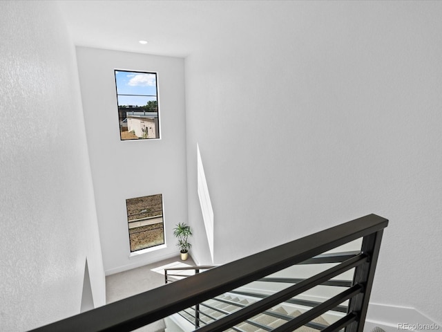 staircase featuring baseboards and carpet