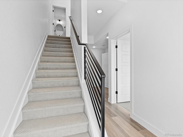 stairway featuring recessed lighting, baseboards, and wood finished floors