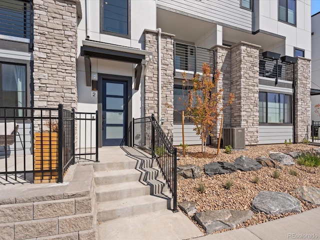 entrance to property with stucco siding and cooling unit