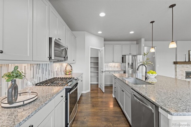 kitchen featuring white cabinets, appliances with stainless steel finishes, dark hardwood / wood-style floors, and sink