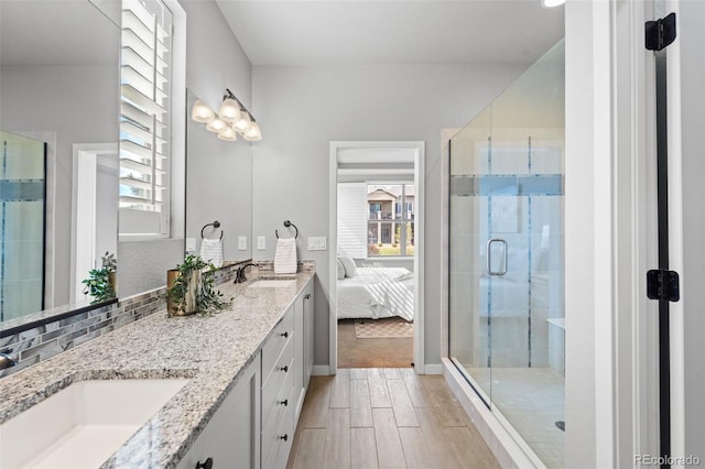 bathroom with a wealth of natural light, hardwood / wood-style floors, vanity, and walk in shower