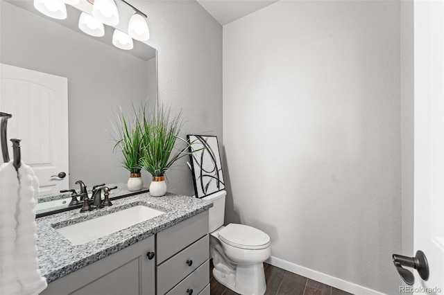 bathroom with vanity, toilet, and wood-type flooring