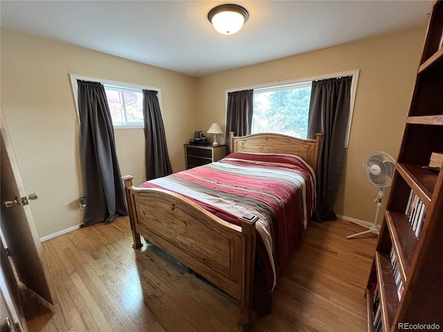 bedroom featuring baseboards and light wood finished floors