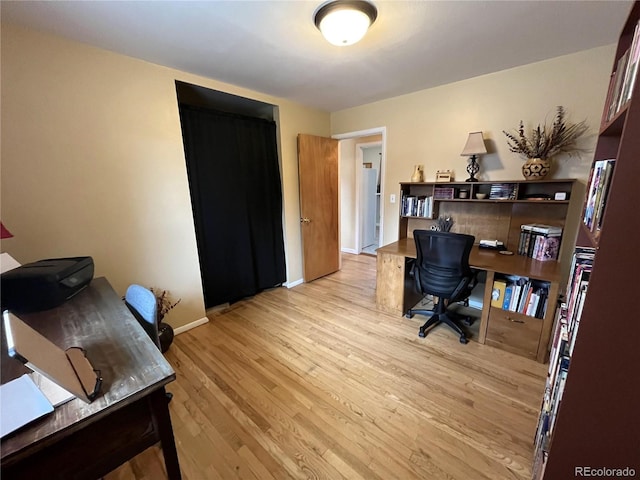 office area featuring light wood-type flooring and baseboards