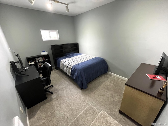 bedroom with carpet, baseboards, and track lighting