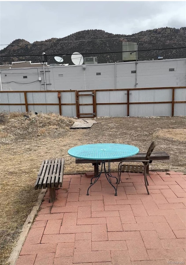 view of patio / terrace with fence and a mountain view