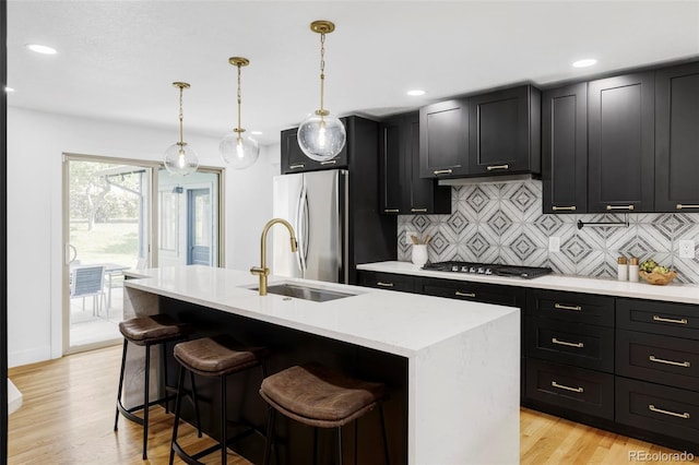10250 W 33rd Ave, Wheat Ridge, CO 80033 - kitchen with dark cabinets, tasteful backsplash, appliances with stainless steel finishes, a center island with sink, and recessed lighting