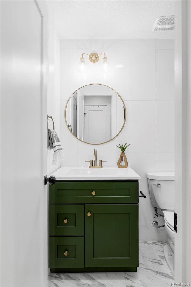 10250 W 33rd Ave, Wheat Ridge, CO 80033 - bathroom featuring marble finish flooring, vanity, and tile walls