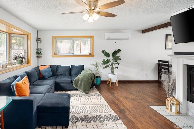living room with a textured ceiling, a wall mounted AC, and a wealth of natural light