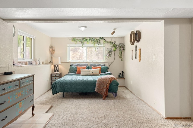 bedroom with baseboards and light carpet