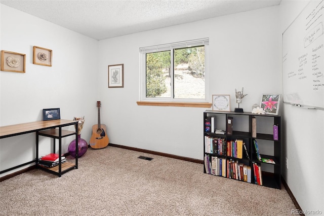 interior space with a textured ceiling, visible vents, and baseboards
