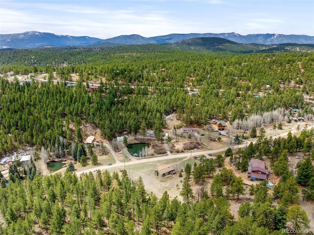 birds eye view of property featuring a view of trees and a mountain view