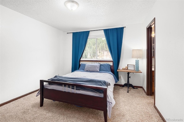 bedroom with baseboards, carpet, and a textured ceiling
