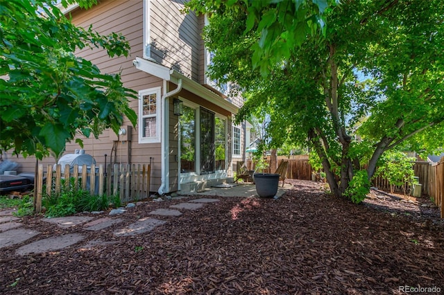 view of home's exterior with a fenced backyard and a sunroom