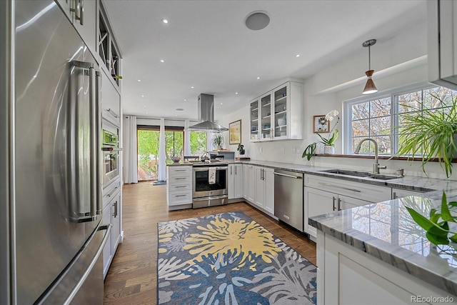 kitchen with stainless steel appliances, island exhaust hood, a sink, plenty of natural light, and recessed lighting