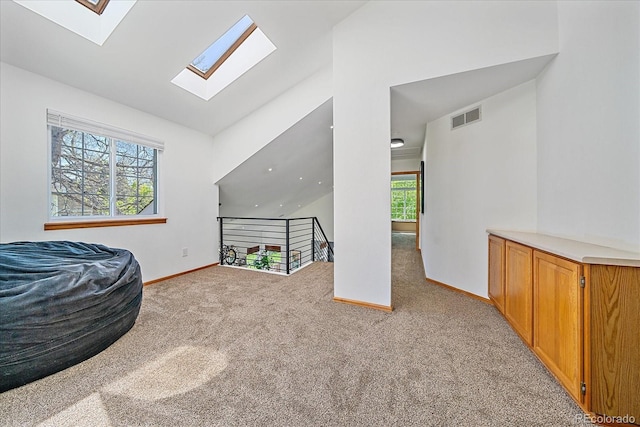 rec room featuring a skylight, carpet, baseboards, and lofted ceiling