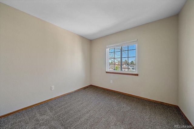 carpeted empty room featuring baseboards