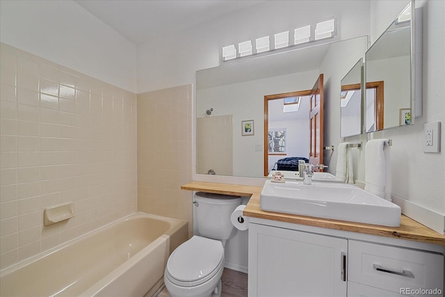 bathroom featuring toilet, ensuite bath, vanity, and shower / washtub combination