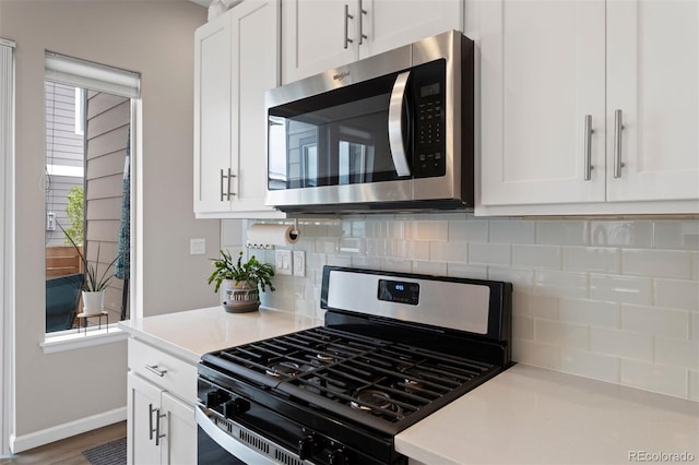 kitchen featuring backsplash, stainless steel appliances, white cabinetry, and plenty of natural light