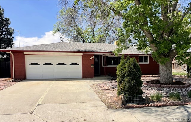 ranch-style home with driveway, a garage, brick siding, and a shingled roof
