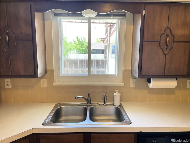 kitchen with a sink, light countertops, dishwasher, and plenty of natural light