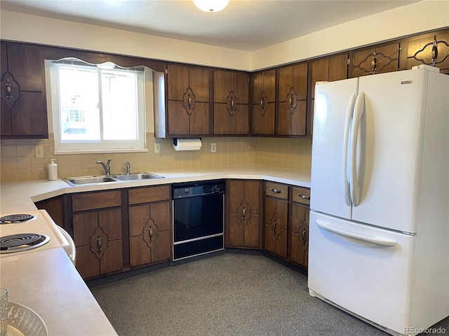 kitchen with freestanding refrigerator, dishwasher, a sink, and light countertops