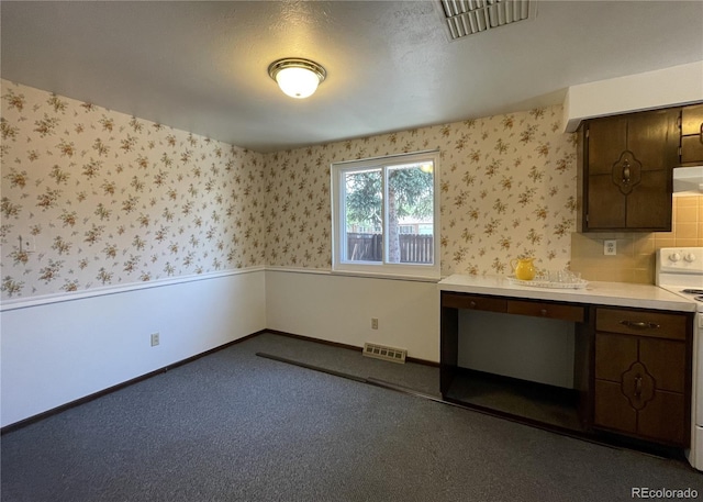 kitchen featuring light countertops, white electric range oven, wallpapered walls, under cabinet range hood, and carpet