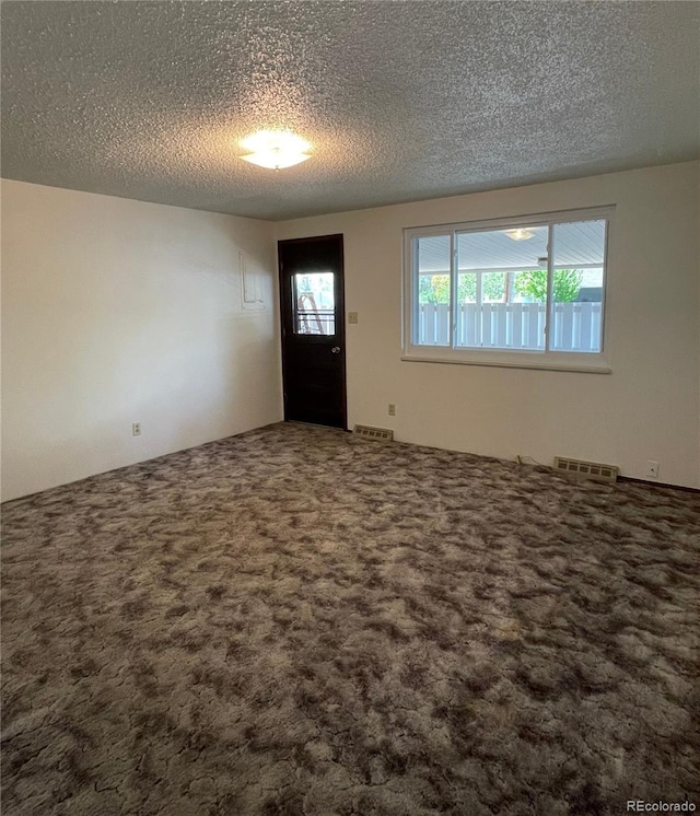 carpeted entryway featuring a textured ceiling