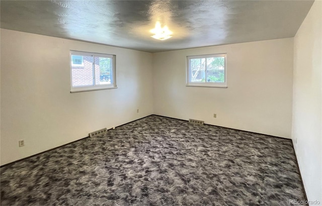 carpeted spare room featuring baseboards
