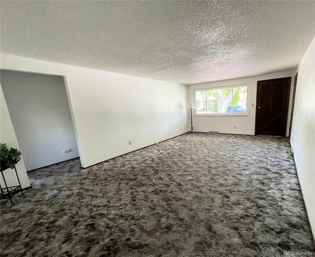 carpeted empty room with a textured ceiling
