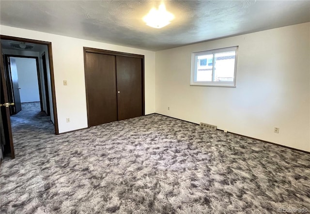 unfurnished bedroom with carpet, a closet, and baseboards
