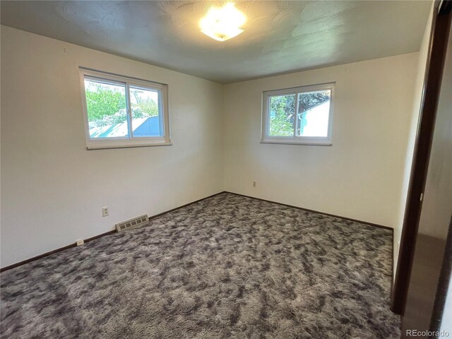 carpeted empty room featuring baseboards