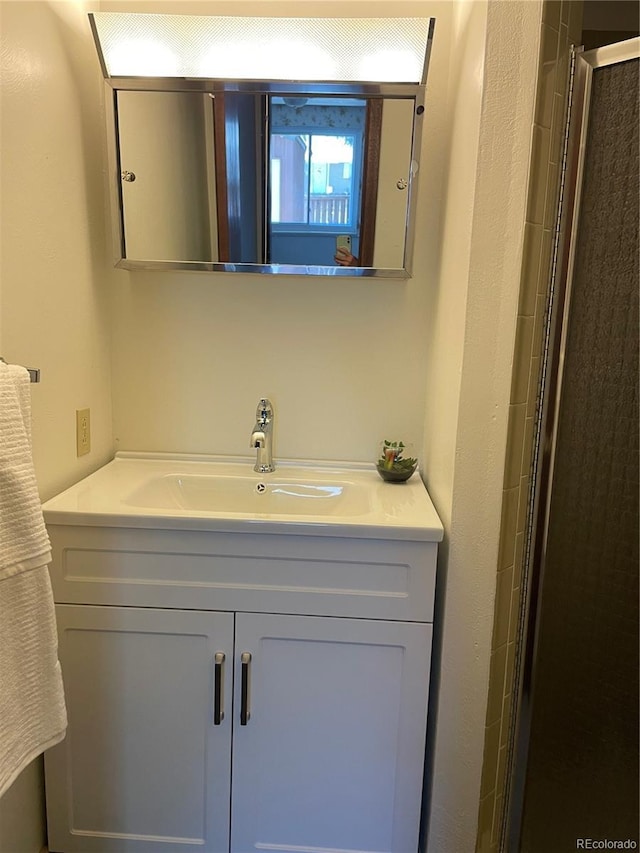 bathroom with vanity and tiled shower