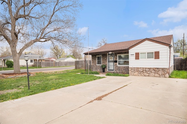 1293 S Perry St, Denver, CO 80219 - view of front of house with stone siding, driveway, and roof with shingles