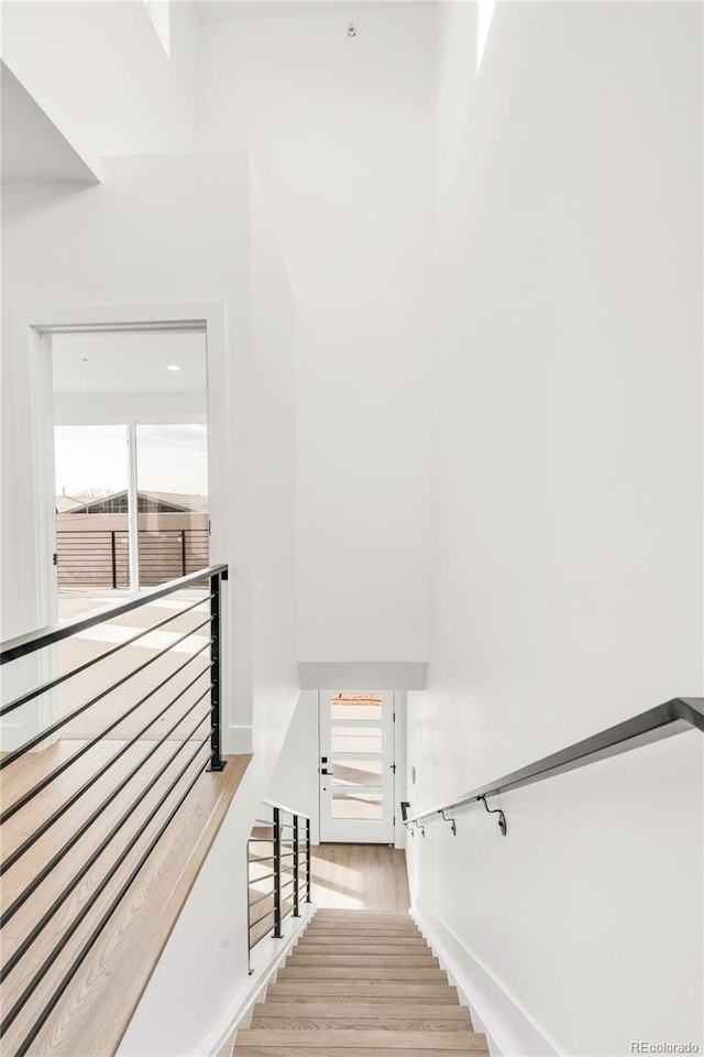 staircase with wood-type flooring and a wealth of natural light