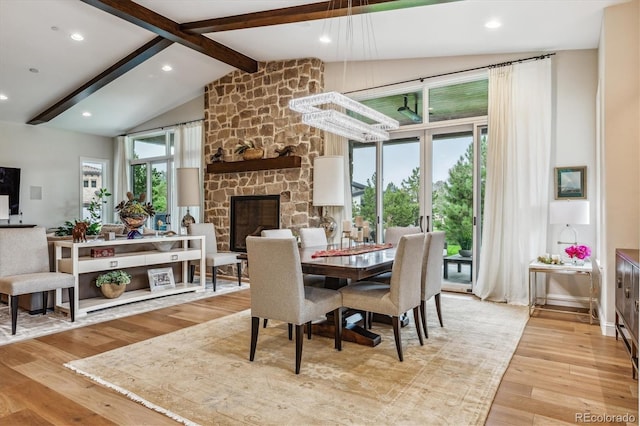 dining area featuring beamed ceiling, light wood-type flooring, a fireplace, high vaulted ceiling, and recessed lighting