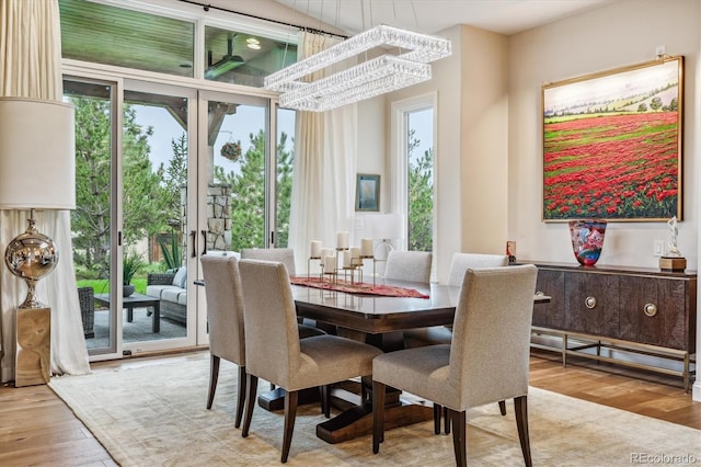 dining space with french doors, light wood-type flooring, and a wealth of natural light