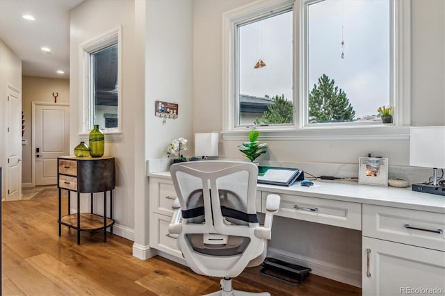 office with light wood-style floors, recessed lighting, built in desk, and baseboards