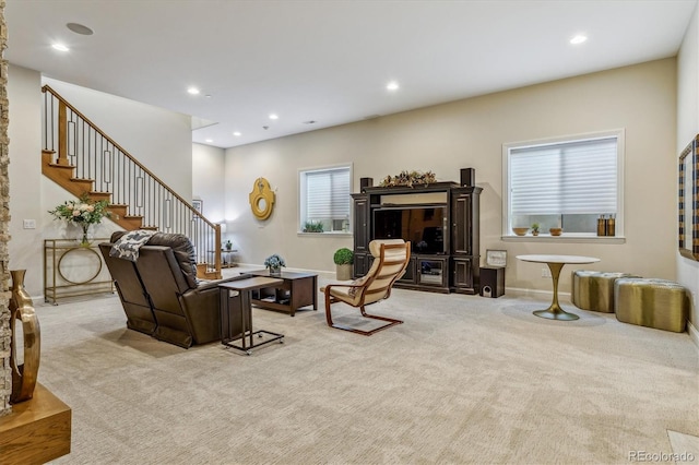 living area featuring recessed lighting, light carpet, and stairs