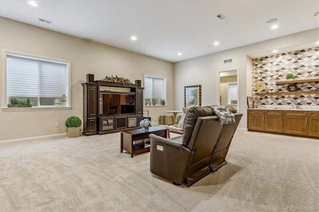 living room featuring recessed lighting, light colored carpet, visible vents, and baseboards