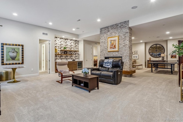 living room with a fireplace, beverage cooler, and light colored carpet